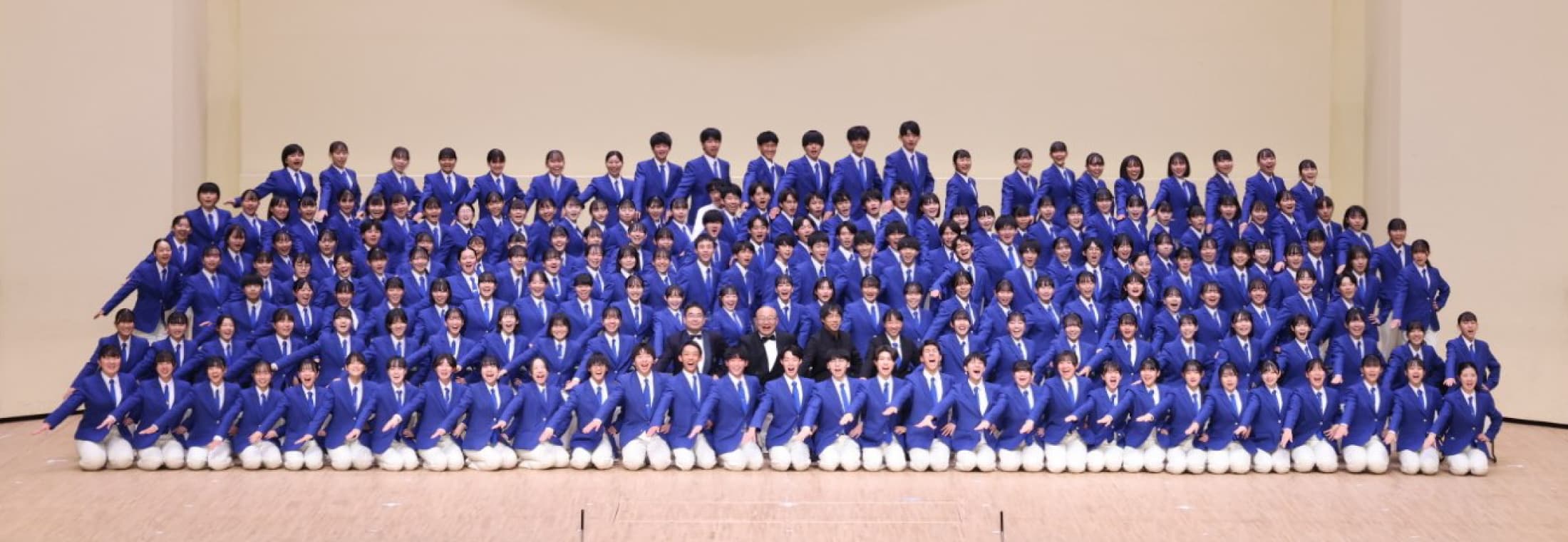 写真:習志野市立習志野高等学校吹奏楽部の部員全員がマリンブルーのジャケットを着て一堂に介している集合写真